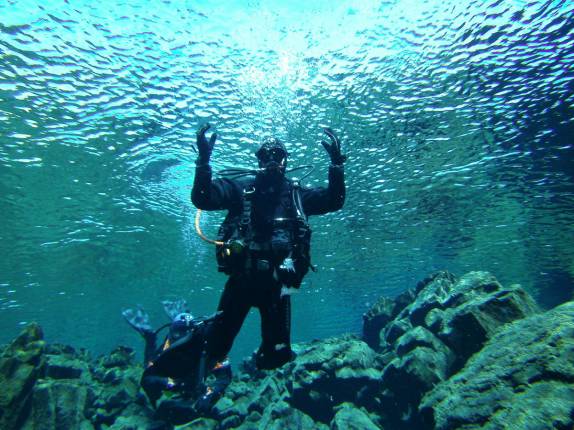 Mergulho nas águas claras e geladas da Silfur Hellir, a fenda que divide a Europa da América, no Parque Nacional Thingvellir, na Islândia